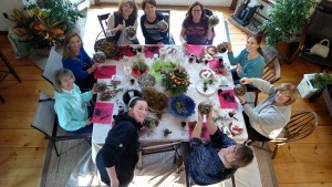 planting partygoers seated around a table working on creating terrariums